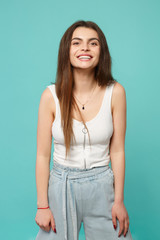 Fototapeta premium Portrait of smiling cheerful young woman in light casual clothes looking camera isolated on blue turquoise wall background in studio. People sincere emotions, lifestyle concept. Mock up copy space.