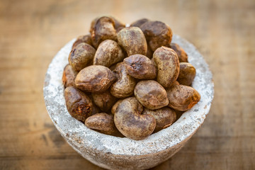 Cashew - bowl filled of raw nuts in the shell