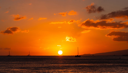 Fototapeta na wymiar Orange and golden sunset at Waikiki Beach Hawaii