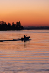 Boat silhouette at sunrise on lake Bodensee, Germany