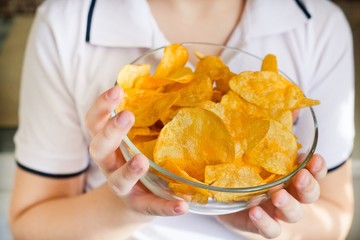 potato chips on a plate in the hands of a child