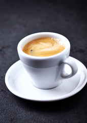 Cup of coffee on black stone background. Close up. Copy space.