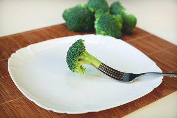 broccoli on a fork on a side plate