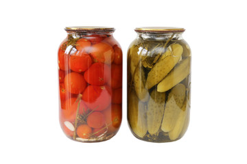 two glass jars with tomatoes and cucumbers closed with a metal lid isolated on white background