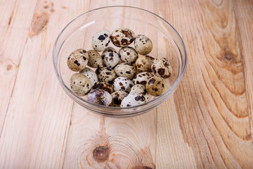 Fresh, farm, raw quail eggs on wooden background. Protein diet. Healthy diet.