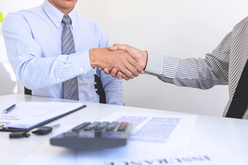 Real estate agent and customers shaking hands together celebrating finished contract after about home insurance and investment loan, handshake and successful deal
