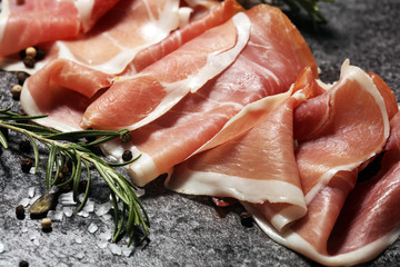 Italian prosciutto crudo or jamon with rosemary. Raw ham with spices