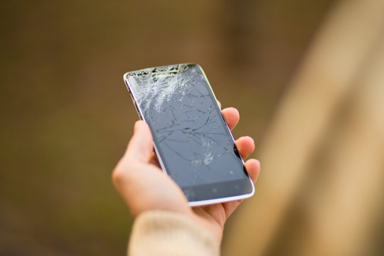 young man hold broken smartphone screen. Broken phone in hand