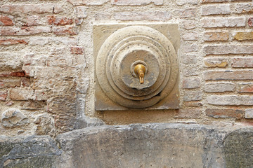 Tourist tap with drinking water in the old town Santarcangelo di Romagna, Rimini, Italy