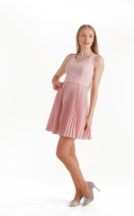 Beautiful young blonde woman in pink dress isolated on white background
