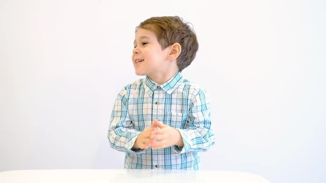 Funny boy rubs hands gloating. Smiling cute little man plotting a good idea.