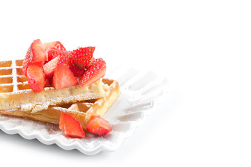 Belgium waffers with sugar powder and strawberries on ceramic plate on white table.