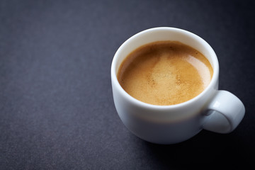 Cup of coffee on black background. Copy space.