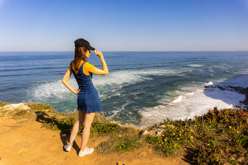 Young woman from back standing on the cliffs