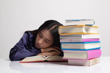 Exhausted Young Asian woman sleep with books on table.