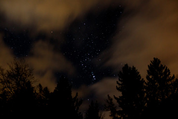 night sky with orion, clouds and trees