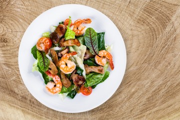 Spaghetti with shrimps, tomatoes and chopped parsley on wooden desk