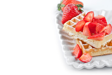 Belgium waffers with sugar powder and strawberries on ceramic plate on white table.