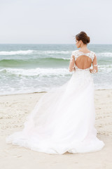 Fototapeta na wymiar back of the bride against the sea in windy weather