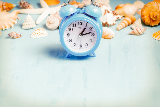 Blue sea background with alarm clocks and seashells, summer holiday and vacation time concept