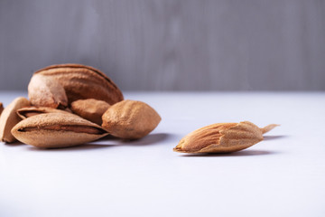 raw whole almond in bowl on gray background.