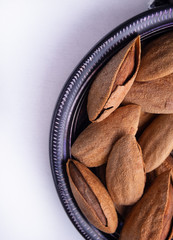 Almonds  in ceramic bowl on rustic table top view