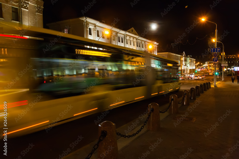 Wall mural motion b lurred bus down the street in the evening.