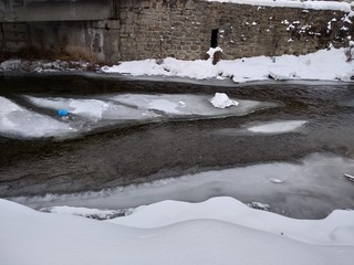 Río congelado con nieve y hielo en temporada de invierno. Rumanía, Transilvania, pueblo de Parva. Paisaje de invierno