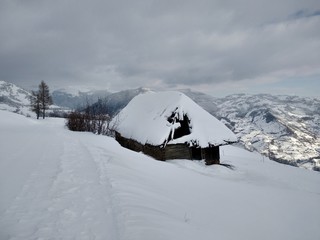 Fototapeta na wymiar Bonito Paisaje de invierno. Cabaña en la montañas de los carpatos cubiertos de nieve en Rumania, Trasilvania, pueblo de Parva.