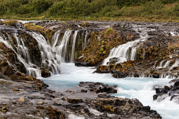Fototapeta na wymiar Scenic view of a wild waterfall with many individual watercourses at a rock stage in the evening light, close up - Location: Iceland, Golden circle, Bruarfoss