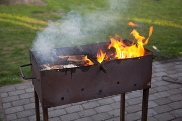 old metal barbecue with fire and smoke on it