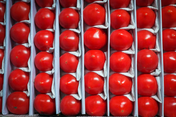 Heap of tomatoes on wholesale market, packed in crates and ready to be sold