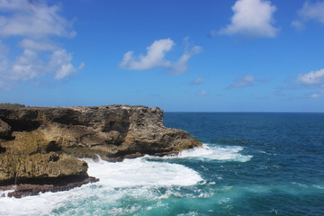 Landscape rock boulder in the middle of ocean with sea foam crashing