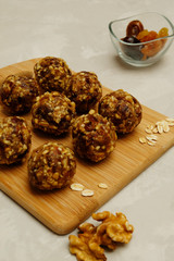 Energy balls - healthy homemade snack rich with fibers and protein. Recipe with oats, walnuts, dates and raisins, selective focus