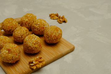 Energy balls - healthy snack rich with fibers and protein. Recipe with walnuts, 	dried apricots and coconut flakes.  Image with copy space, selective focus