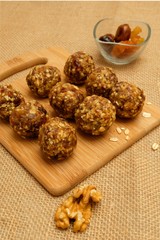 Energy balls - healthy sugarfree fiber-rich snack. Recipe with oats, walnuts, dates and raisins, selective focus