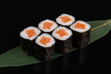 Sake maki Japanese sushi rolls with salmon on black background