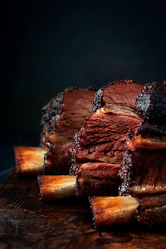 Smoked beef brisket on the ribs with a dark crust on a wooden Board. Classic Texas barbecue