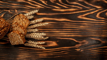 Delicious freshly baked brown bread on wooden background. top view, space for text