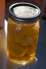 jar of  cut up lemons in water on a counter in a kitchen