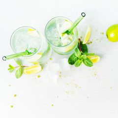 Top view of two glasses with tropical mojito cocktail on light background with copy space. Summer time vacation concept.Flat lay.