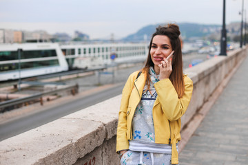 Obraz premium young beauty girl talk on phone on Budapest parliament background 