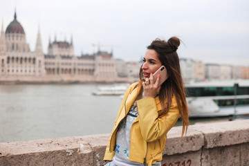 Fototapeta premium young beauty girl talk on phone on Budapest parliament background 