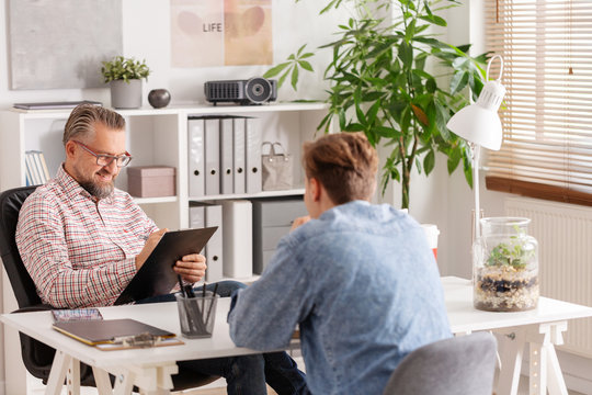 Senior Account Manager And Young Man During Job Interview In Small Firm