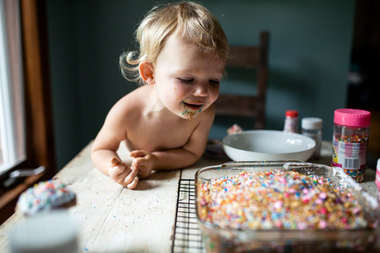 Toddler eagerly looking at freshly baked cake on cooling rack