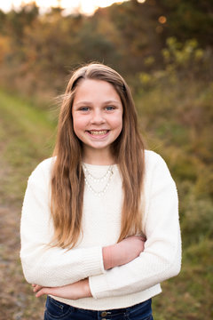 Smiling 13 Year Old Girl Stands Confidently at Sunset on Trail