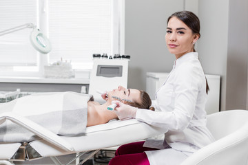 Young beautiful girl on the massage treatment of the face side view. Body care at the Spa