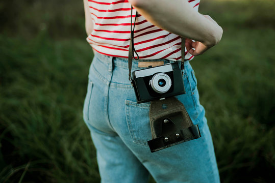 Woman is holding an anlog camera.
