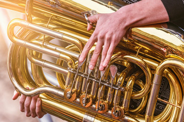 Musician playing tuba at evening time on the city square. - obrazy, fototapety, plakaty