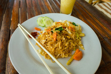 Pad thai noodles with chicken, carrot, shallots and cucumber.